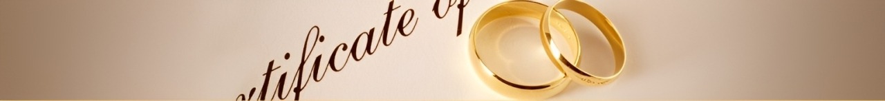 Golden wedding rings rest beside an elegant certificate, symbolizing marriage and commitment. Perfect for wedding planning or legal discussions.
