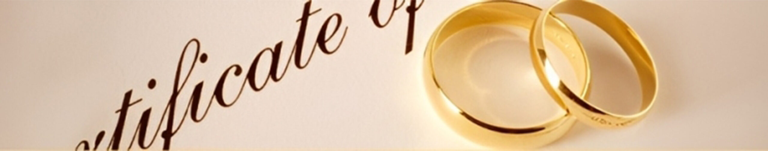 Golden wedding rings rest beside an elegant certificate, symbolizing marriage and commitment. Perfect for wedding planning or legal discussions.